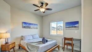 A bedroom with a bed, a desk, a chair, a ceiling fan, and two paintings on the wall. - Mountain Haven Retreat w/Hot Tub & Sauna STR-283 (Buena Vista)