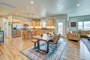 A spacious kitchen with wooden cabinets, a central island, and a dining area with chairs.