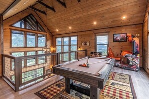 A wooden room with a pool table, large windows, and a view of the mountains. - New Lux 4 King Suites | Hot Tub | Game Rm | PS5 (Gatlinburg)