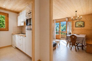 A kitchen with white cabinets and a dining area with a table and chairs.