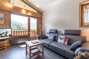 Ein gemütliches Wohnzimmer mit einer Couch, einem Couchtisch und einem Fernseher.