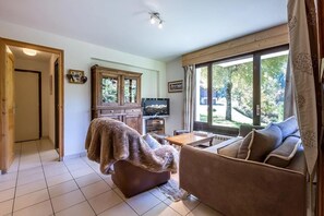 A cozy living room with a sofa, a wooden cabinet, and a television.