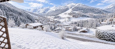 A snow-covered mountain village with buildings and a road.
