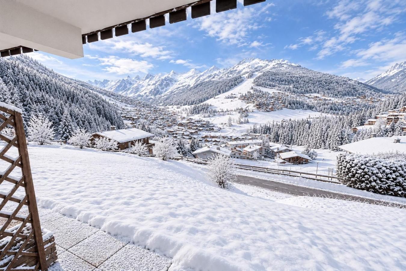 A snow-covered mountain village with buildings and a road.
