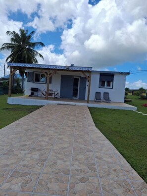 A single-story house with a covered patio, a door, and a small porch area.