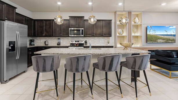 A modern kitchen with dark wood cabinets, stainless steel appliances, and a central island with bar stools. - 8BR house sleeps 16 with private pool (Davenport)