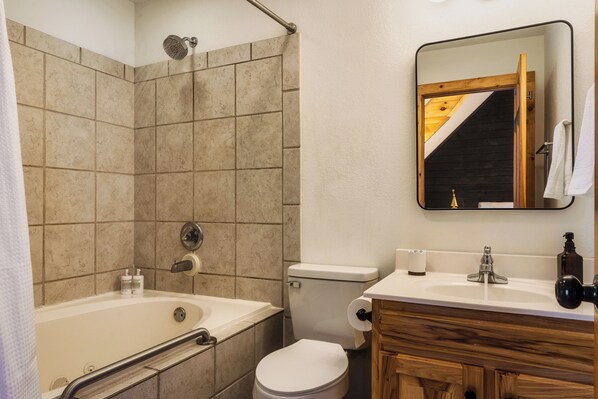 A bathroom with a bathtub, toilet, and sink.