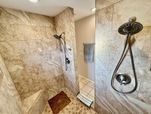 A bathroom with a shower, tiled walls, a towel rack, and a small rug. - Tranquil Foothills Retreat  (Yuma)