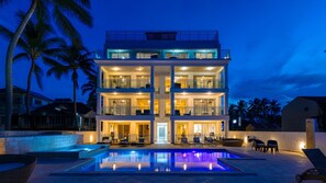 A multi-story hotel with a swimming pool, balconies, and palm trees. - Ocean Front Hot tub Pool Kite Beach Condo 101 (Kite Beach)