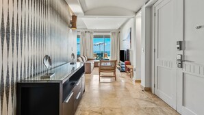 A modern hotel room with a kitchen area, a dining table, and a view of the ocean. - Ocean Front Hot tub Pool Kite Beach Condo 101 (Kite Beach)