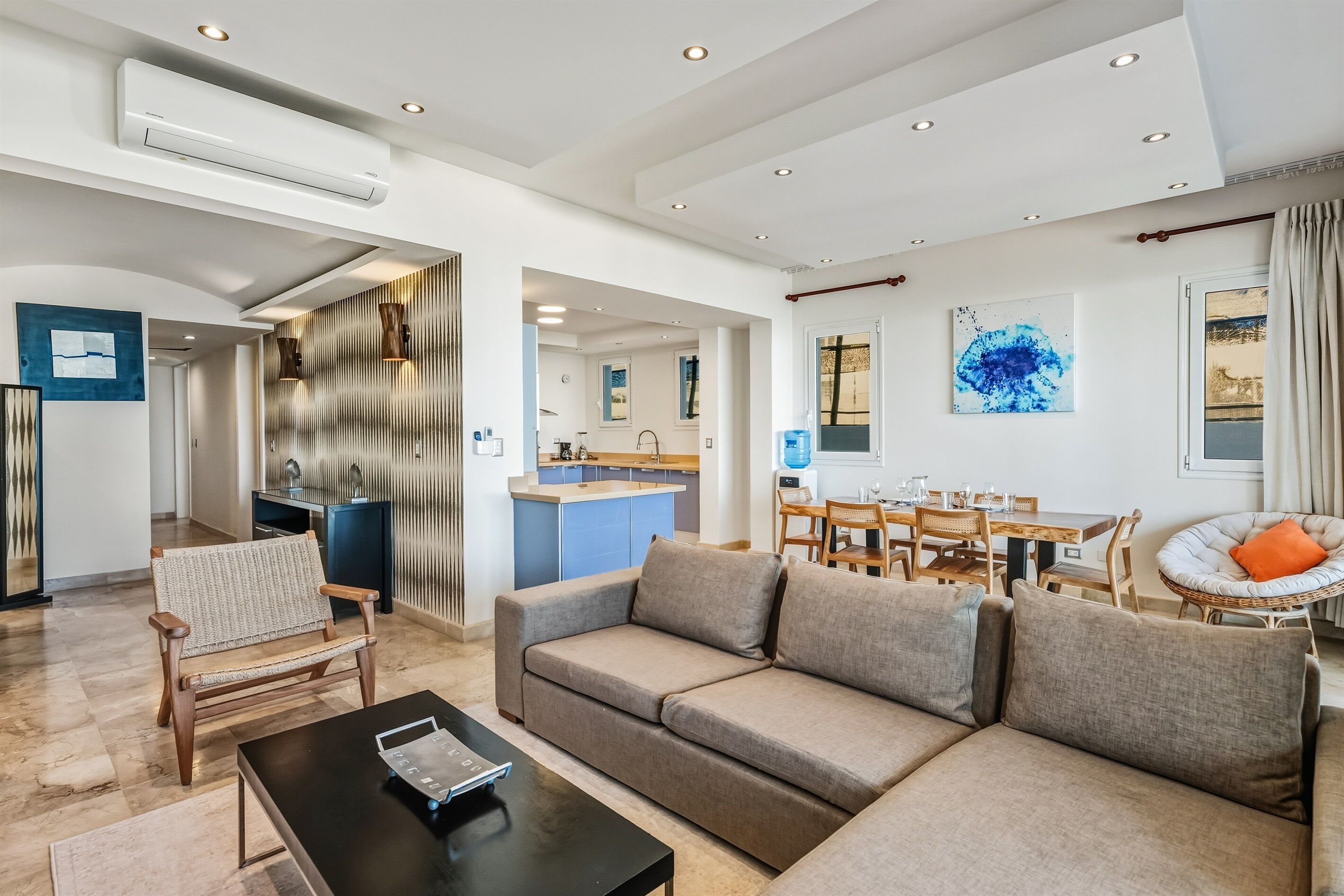 Ein modernes Wohnzimmer mit einer Couch, einem Couchtisch und einem Essbereich mit Tisch und Stühlen.