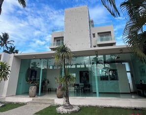 A modern building with a glass facade, a flat roof, and a central entrance. - Oceanfront Hot Tub Pool King Size Bed 305 (Kite Beach)