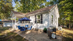 A house with a covered patio, outdoor furniture, and a grill.