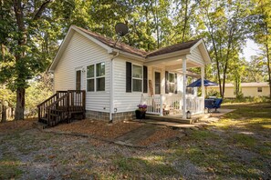 A single-story house with a porch, a welcome sign, and a satellite dish. - Cozy, Pet Friendly Cottage near Lake of Egypt (Goreville)