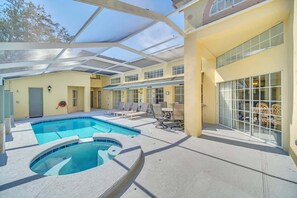 Une piscine intérieure dotée d’un toit en verre, de chaises longues et d’un patio ensoleillé.