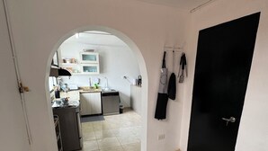 An interior view of a modern apartment with a kitchen area visible through an archway. - Beautiful 3-bed 2-bath aptartment on la 70 with Air conditioning (Medellín)