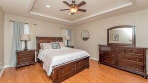 A bedroom with a bed, nightstands, dresser, ceiling fan, and a mirror. - Charming 2-bedroom, 2bath home in lovely Hammond (Hammond)