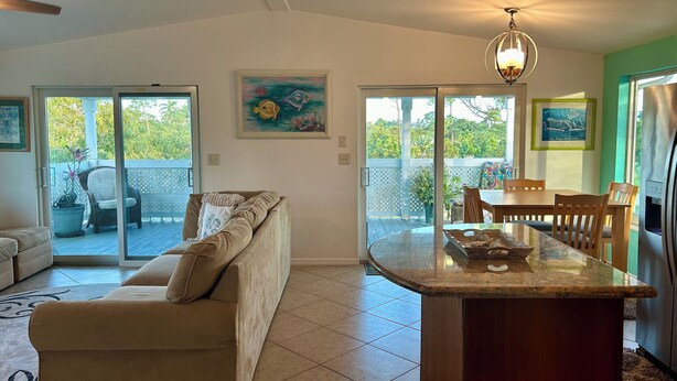 Amplia sala de estar con sofá, mesa de comedor y isla de cocina.