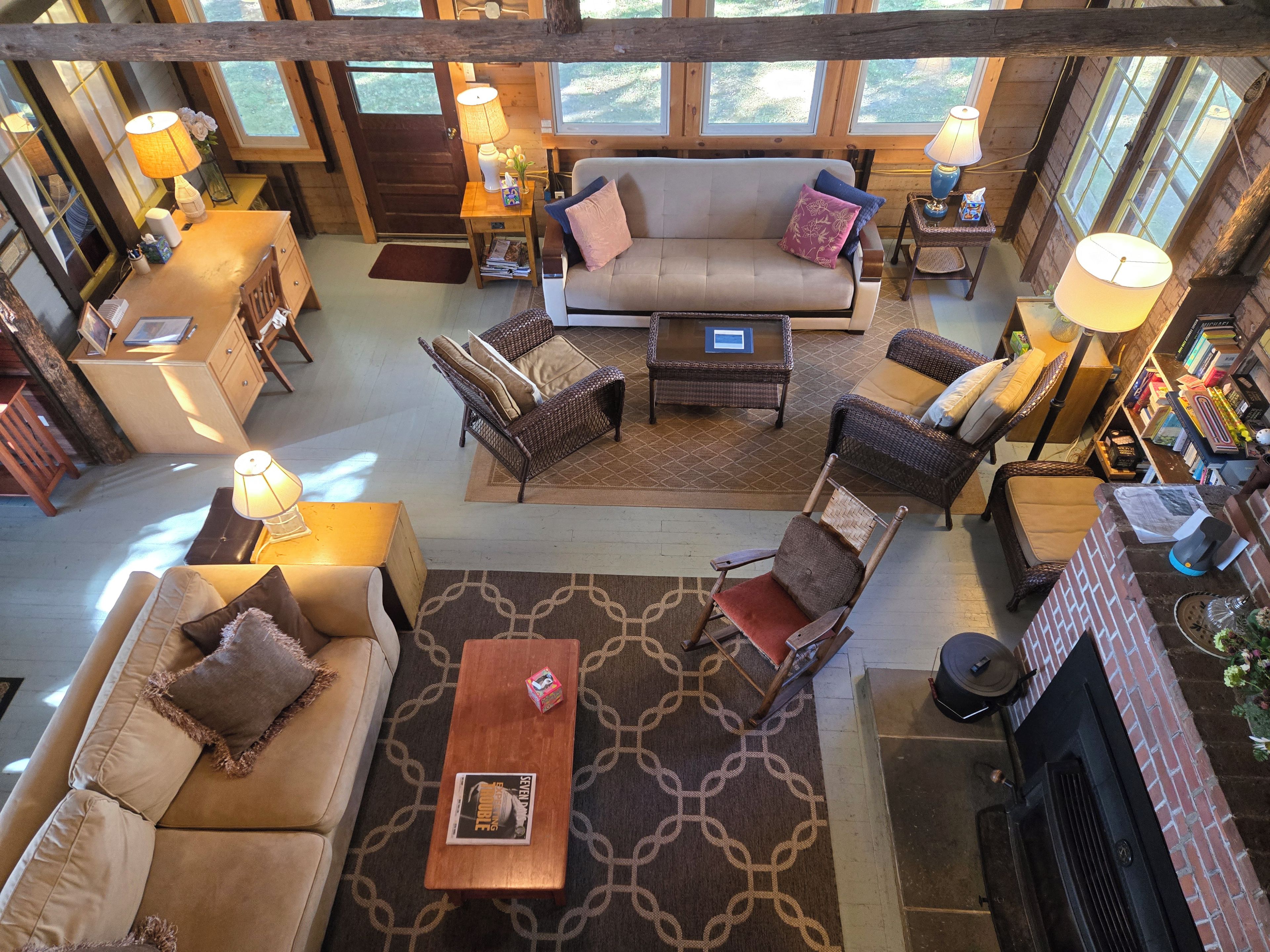 A spacious living area with a sofa, armchairs, a coffee table, and a fireplace.