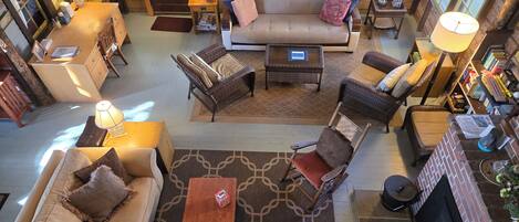 A spacious living area with a sofa, armchairs, a coffee table, and a fireplace.