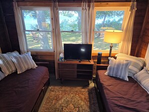 Une chambre confortable avec deux lits, une télévision et une lampe.