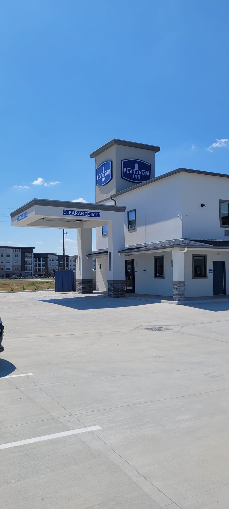 A Platinum Inn with a clear sign, a gas station with a 14'-0" clearance, and a parking lot.