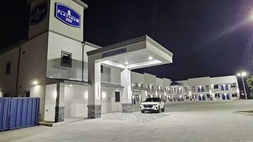 A Platinum Inn hotel entrance with a clearway sign, multiple parking bays, and a white car parked in front.