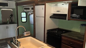A compact kitchen with a sink, stove, and cabinets.
