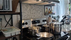 A modern kitchen with stainless steel appliances, a microwave, and various pots and pans. - Your-Holiday home fortuna arenal with swimming pool (La Fortuna)