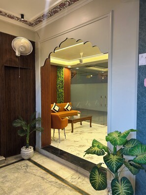 Un interior moderno con sofá y mesa de centro, una pared decorativa y una planta en maceta.