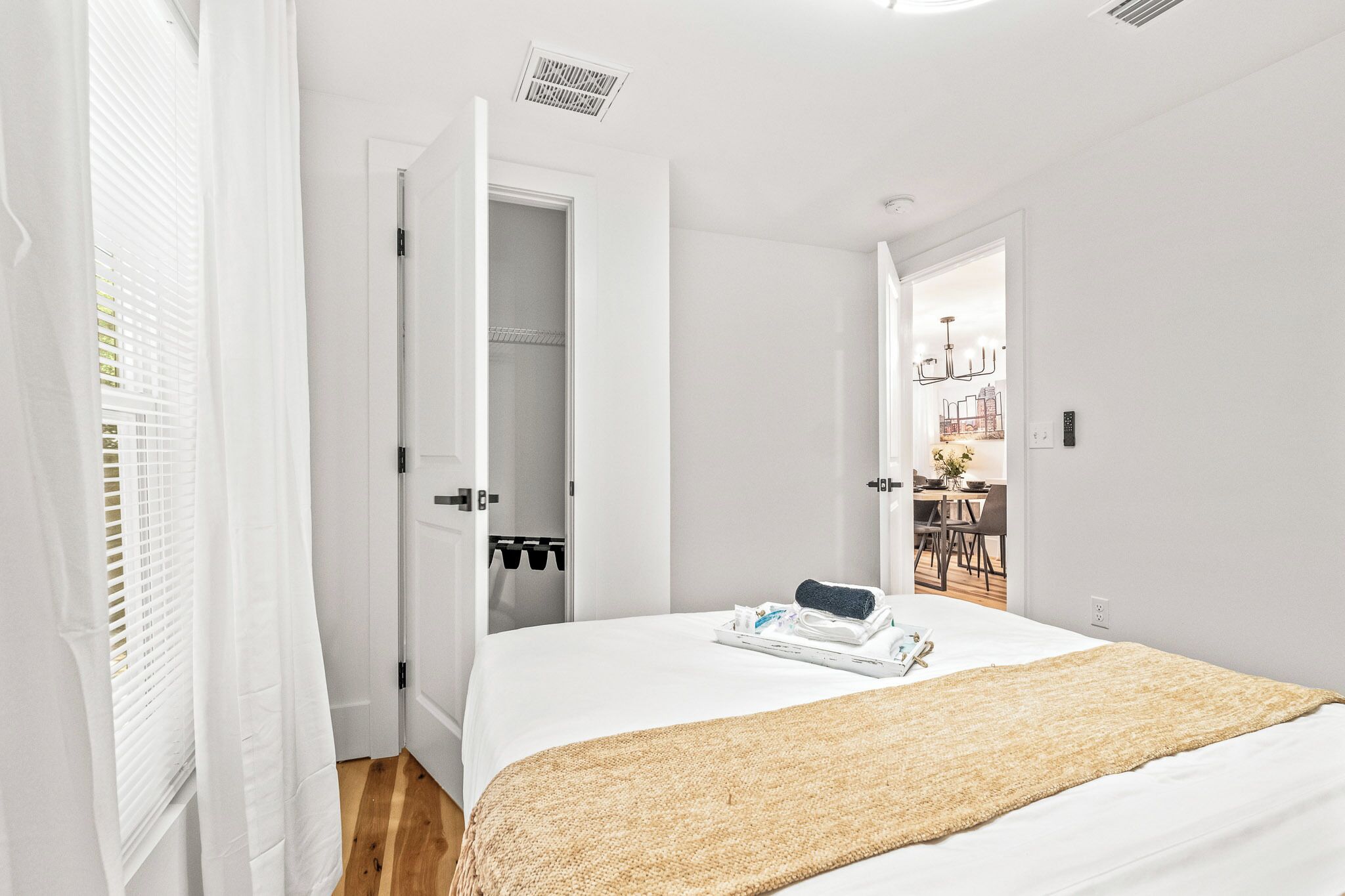 Una camera da letto con un letto, un armadio e vista su un'altra stanza.