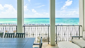 A covered outdoor seating area with a view of the ocean.