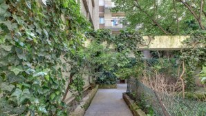 A narrow pathway flanked by dense greenery and a building with balconies. - An Attractive flat near by St-Germain, Le Bon Marché (Paris)