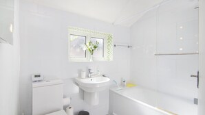 Une salle de bain moderne équipée de toilettes, d’un lavabo et d’une douche.