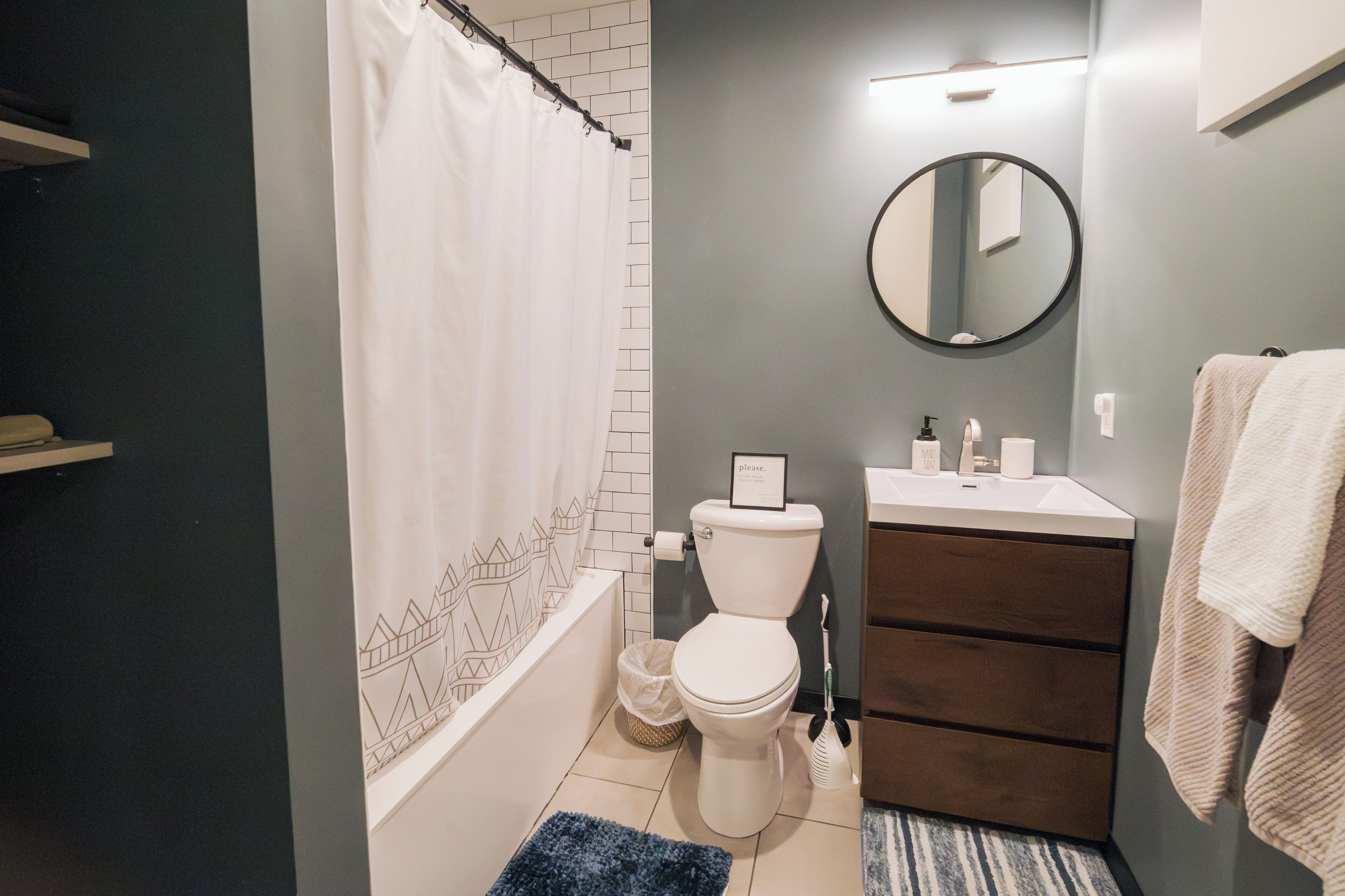 A bathroom with a white toilet, a sink, a mirror, and a towel rack.