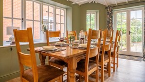Comedor con una mesa de madera dispuesta para seis personas, rodeado de sillas.