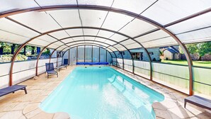 A covered swimming pool with lounge chairs and a view of a stone building. - Beautiful home in Rubercy with sauna (Rubercy)