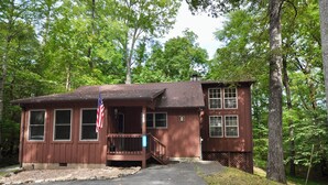 A two-story cabin with a porch, a small deck, and an American flag. - Trails End, your own private retreat in the Smokies! (Townsend)