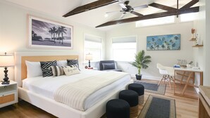 A bedroom with a large bed, bedside tables, a desk, and a chair.