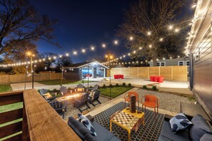 A backyard with a fire pit, outdoor seating, and string lights. - The Nashville Getaway - Huge Backyard, Fire Pit, Movie & Game Room  (Nashville)