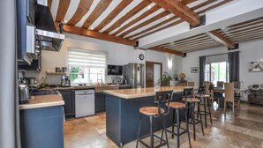 A spacious kitchen with a large island, modern appliances, and a rustic wooden ceiling. - Awesome home in Villecroze (Villecroze)