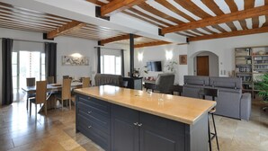 A spacious living area with a large kitchen island, wooden beams on the ceiling, and a cozy seating arrangement. - Awesome home in Villecroze (Villecroze)