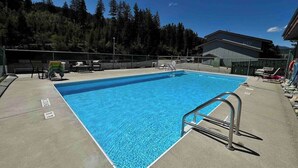 A rectangular swimming pool with a metal ladder on one side, surrounded by a concrete deck. - On Hill Mountain Retreat (Kimberley)