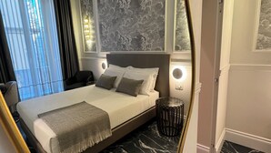 A modern bedroom with a large bed, marble flooring, and a view of the city through the window. - Lovely rooms (La Spezia)