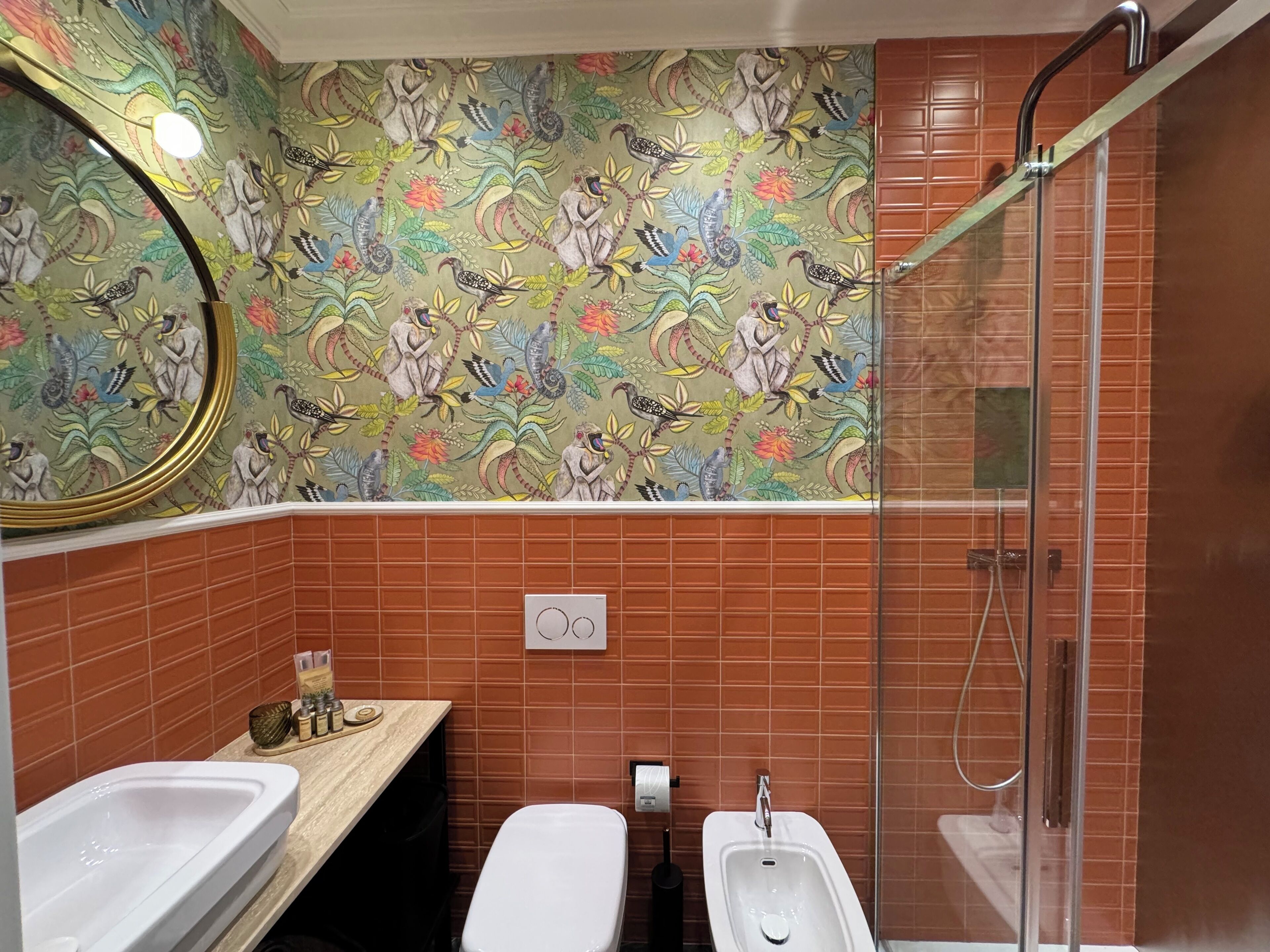 Ein Badezimmer mit Dusche, zwei Waschbecken, Toilette und Spiegel.