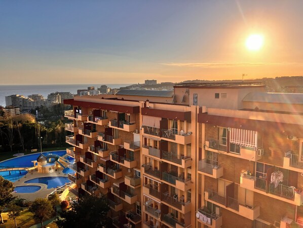 A multi-story residential building with balconies, a swimming pool, and a view of the sea. - Modern Studio Sea Views in Benalmádena - Available for weekly or monthly rentals (Benalmádena)