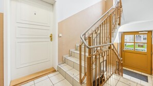 A staircase with metal railings and wooden steps leading to a landing. - 1 bedroom lovely apartment in Anklam (Anklam)