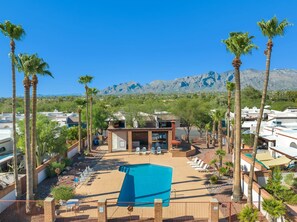A resort with a pool, palm trees, and mountains in the background. - City Center Townhouse with Private Yard! (Tucson)