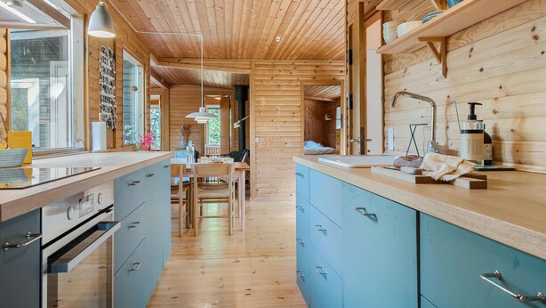 Een moderne keuken met houten kastjes, een centraal eiland en een zithoek.