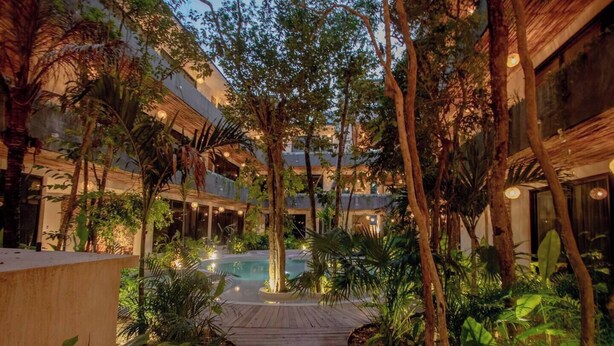 A courtyard with a pool, surrounded by trees and buildings. - HEAVENLY MAYAN ESCAPE CHIC 1 BDRM APT 250 MB WiFi IN HEART OF TULUM, PLUNGE POOL (Tulum)
